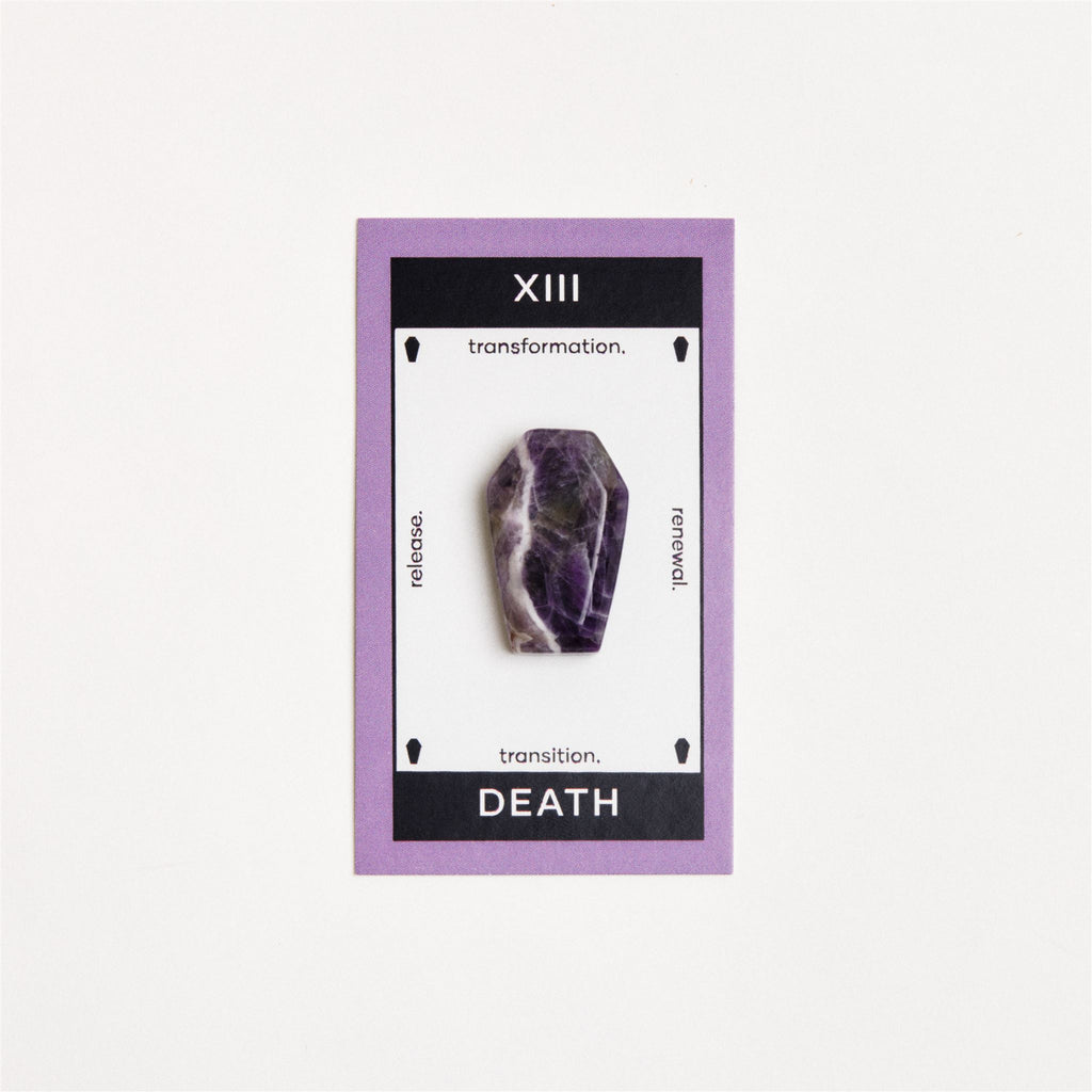 amethyst coffin shaped crystal on white surface