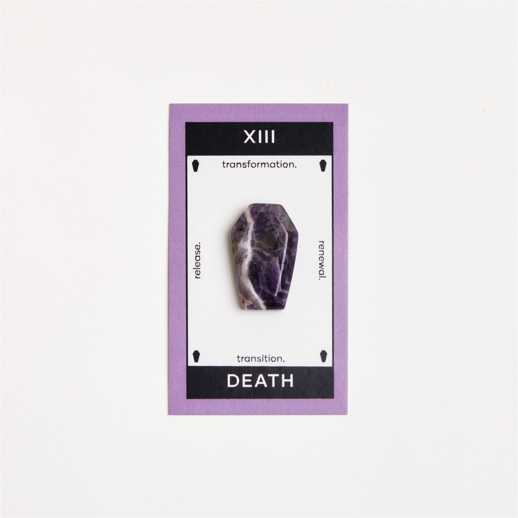 amethyst coffin shaped crystal on white surface