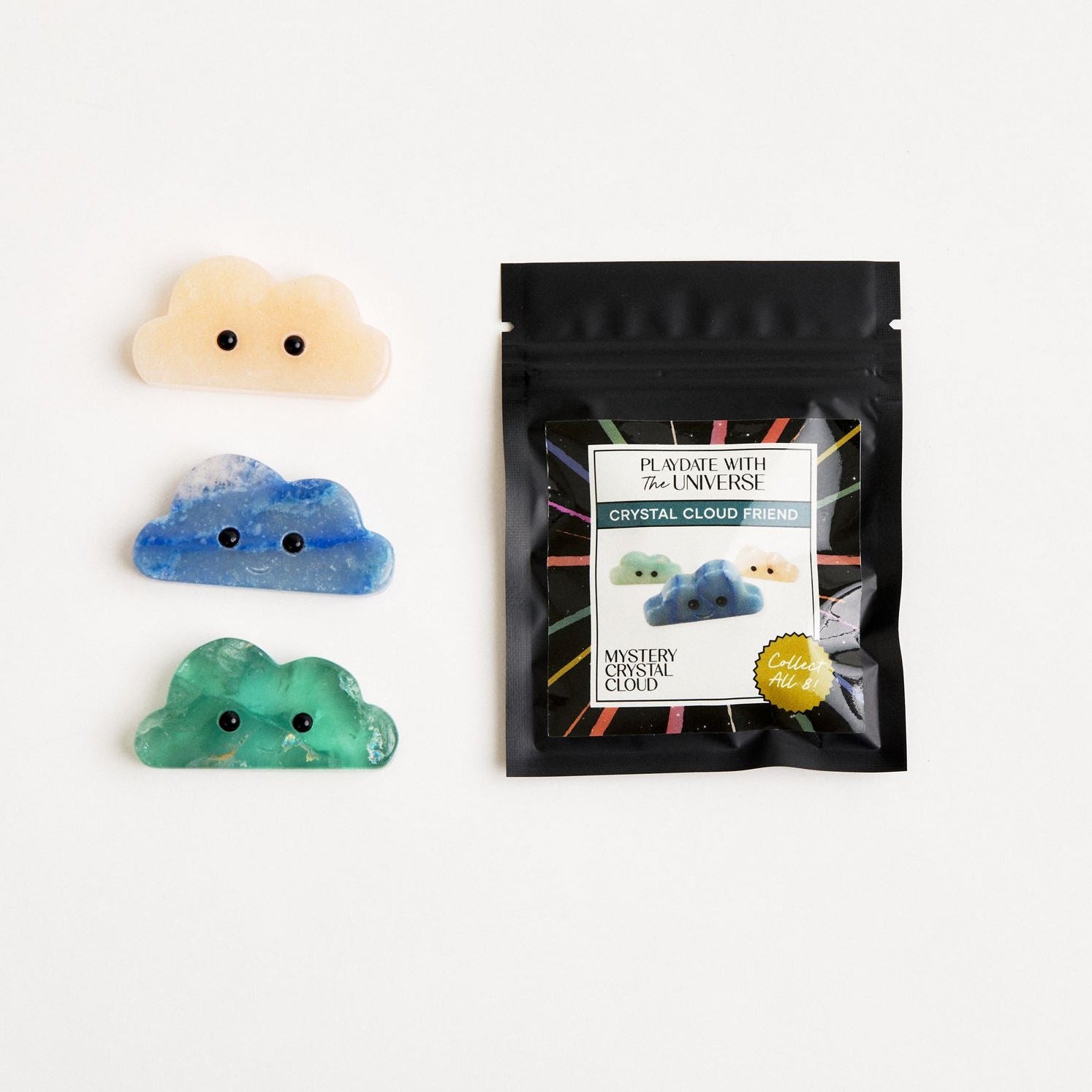 3 crystal clouds sitting next to mystery packaging 