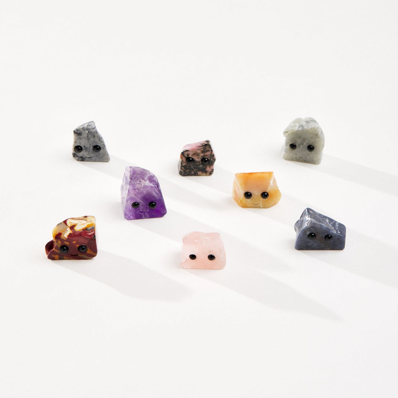 Assortment of crystal pet rocks on a white background