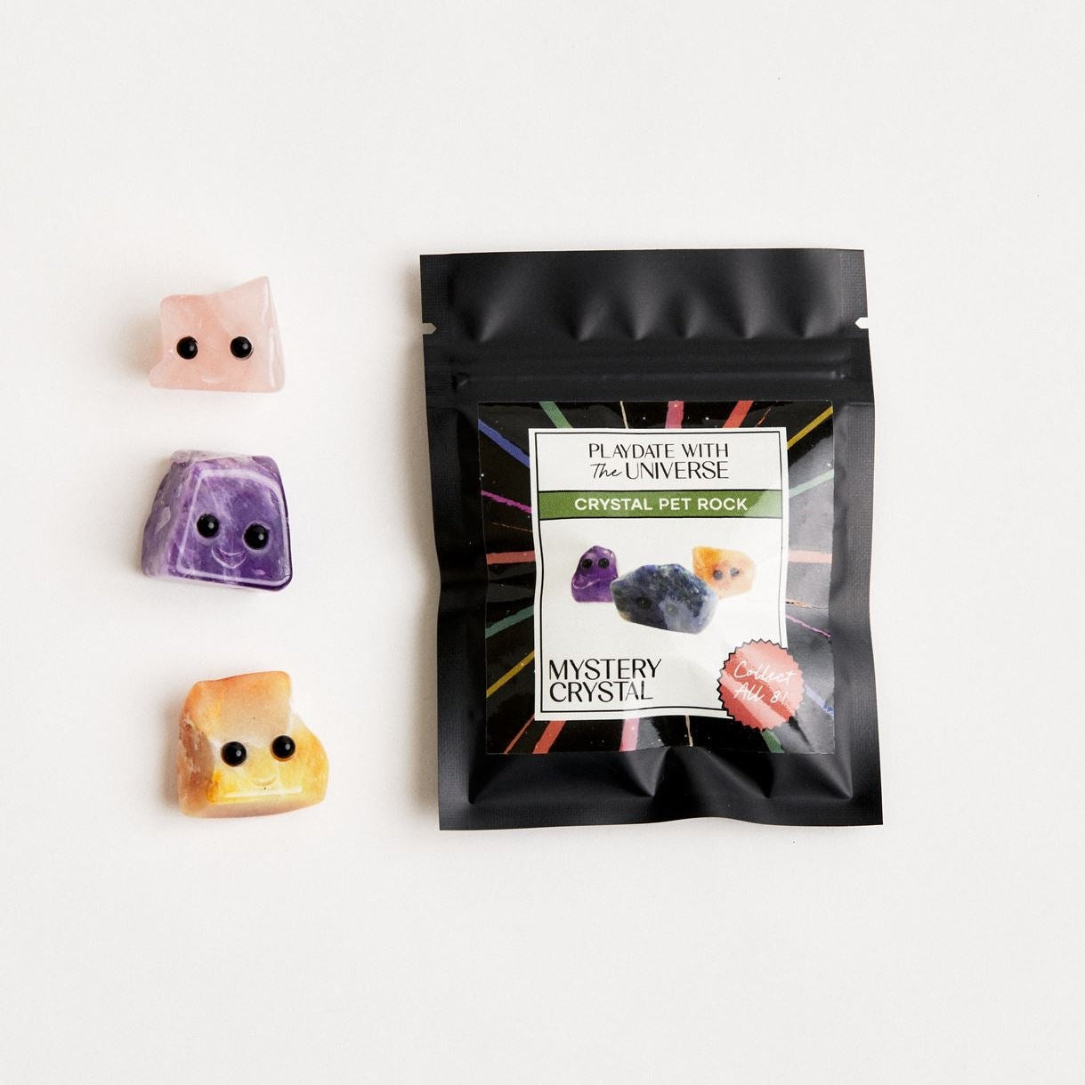 3 crystal pet rocks laying next to mystery packaging