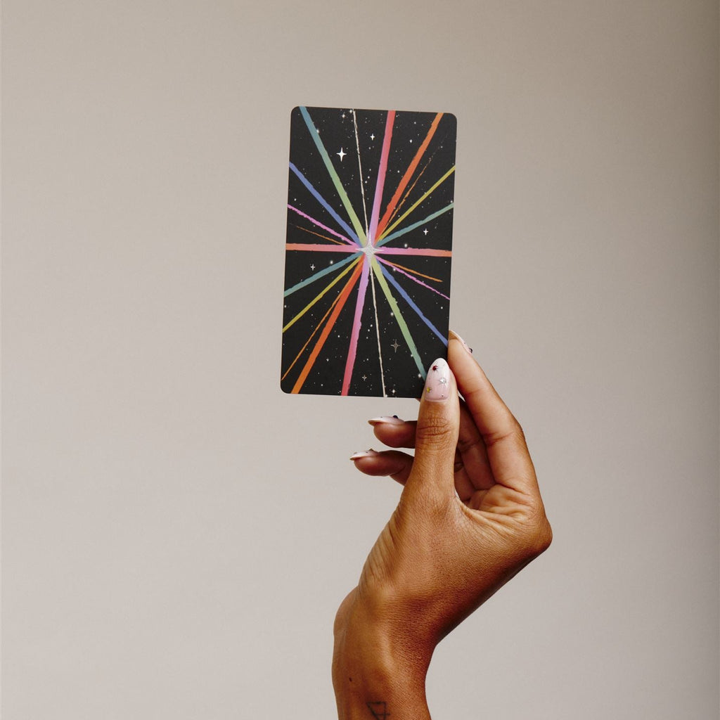 Hand holds single tarot card to show the back detail