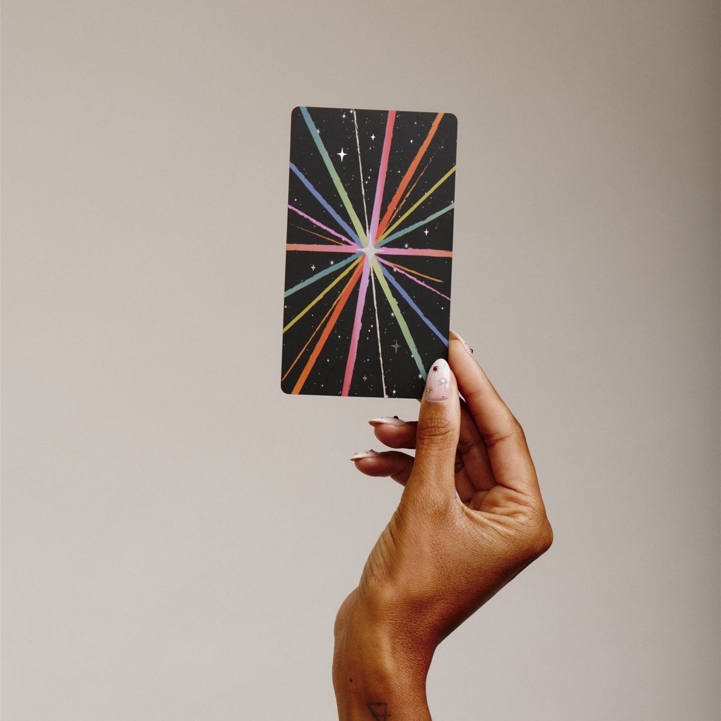 Hand holds single tarot card to show the back detail