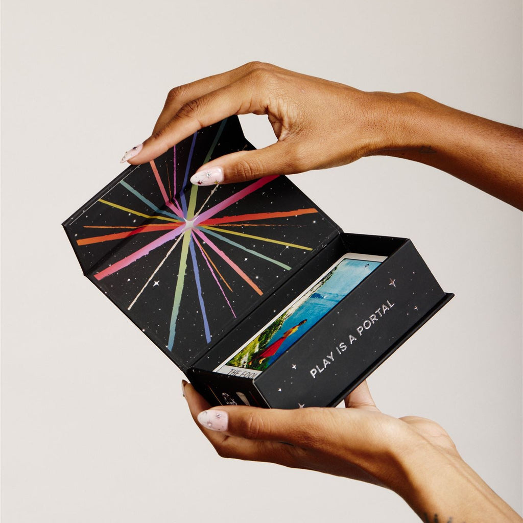 hands holding a tarot box opening to show the deck inside and details of inside the box lid
