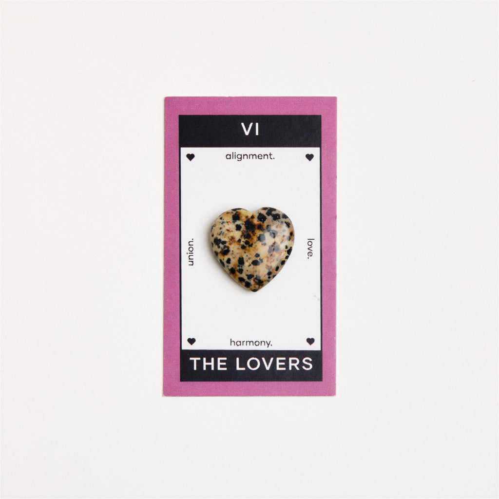 dalmatian jasper heart shaped crystal on white surface