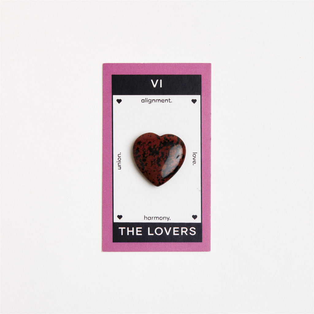 mahogany obsidian heart shaped crystal on white surface
