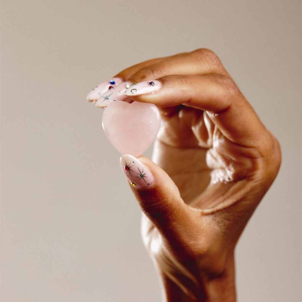 hand holding heart shaped crystal